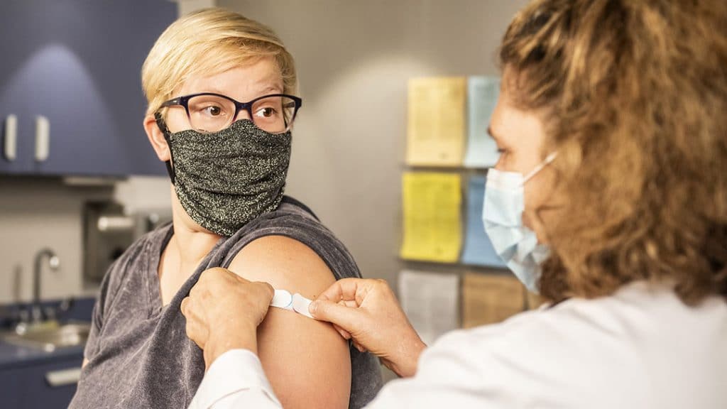 Female nurse applying bandaid in examination room